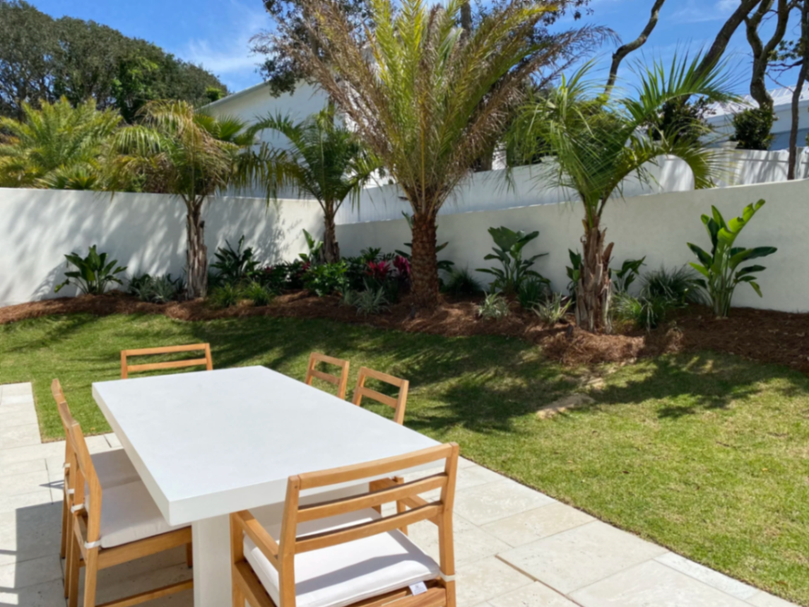 Patio with privacy wall and tropical bed
