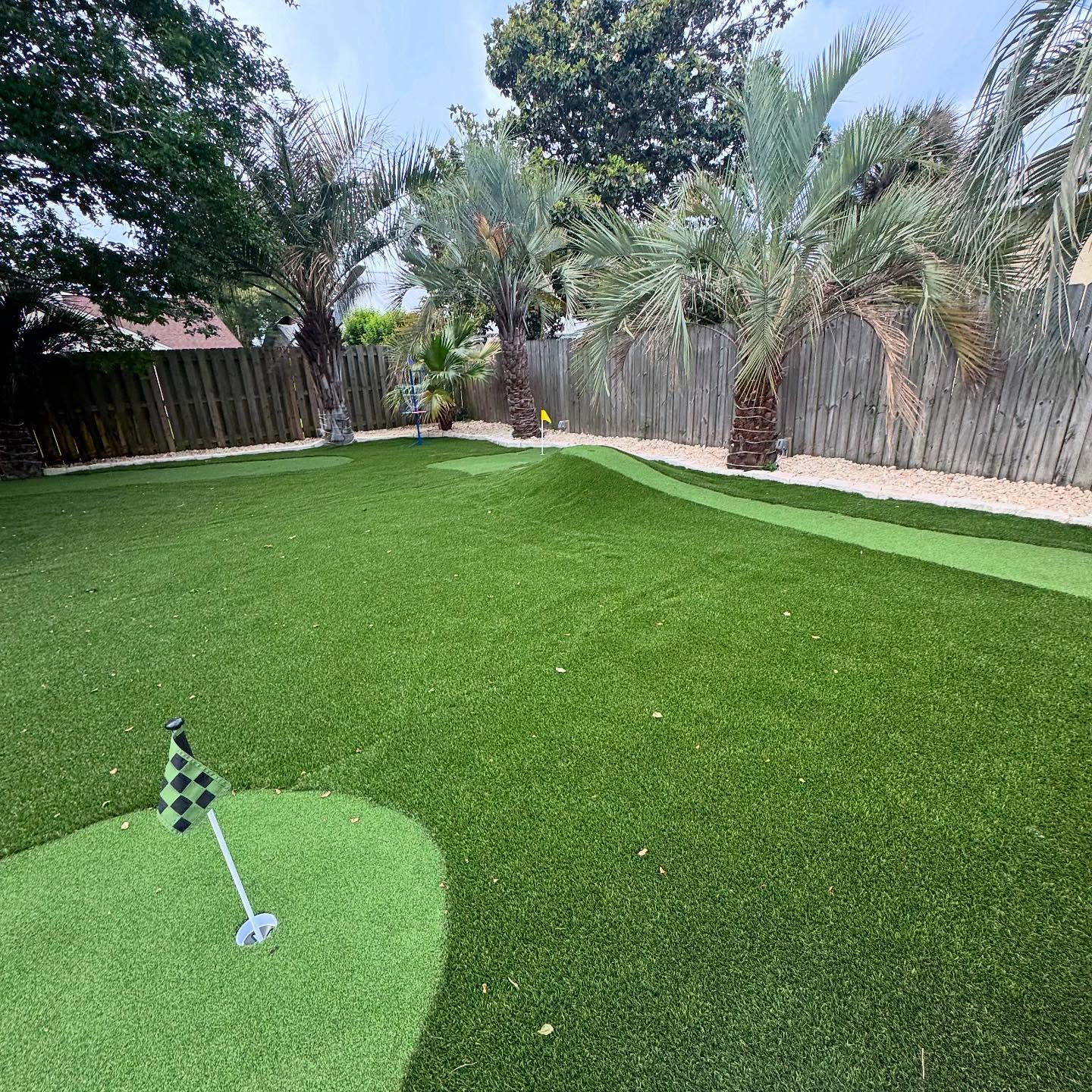 Backyard putting green install with palms